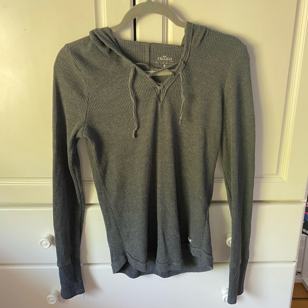 Long sleeve grey sweater with a hood.